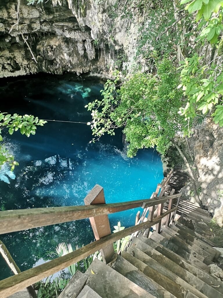 a ladder leading down to azure water of cenote near Merida
