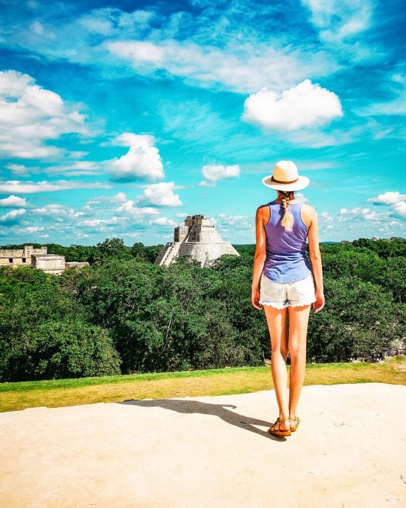 Girl watching Uxmal Mayan Ruins hidden in the jungle