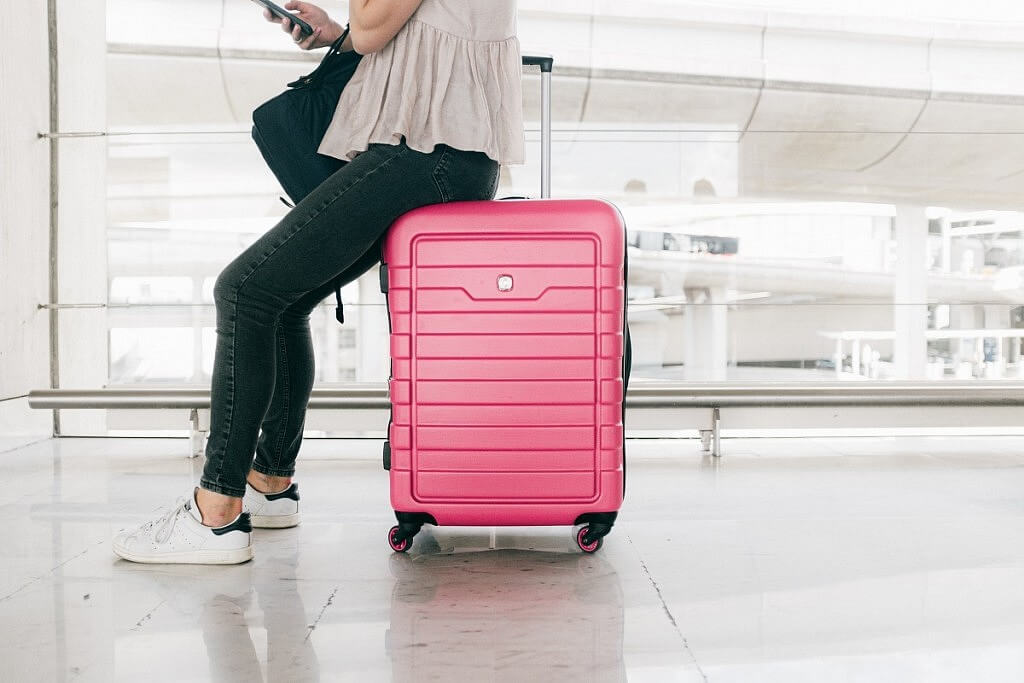 woman waiting in the airpor with a luggaget