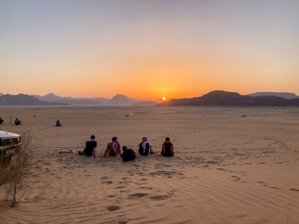 A group of people watching sunset in Wadi Rum